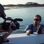 Bo Lusk explains the growth of a natural oyster reef to cameraman John Molinelli during the filming 
of special features for the Our Island Home Expanded Edition DVD.   Photo by James Spione.